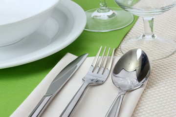 Table setting with fork, knife, spoon, plates, and napkin