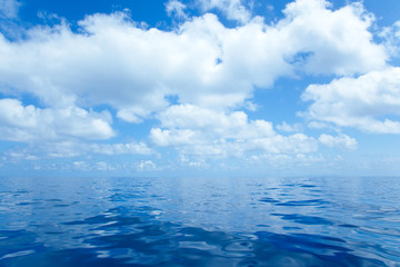 Fototapeta na wymiar Blue calm sea water in with clouds mirror surface