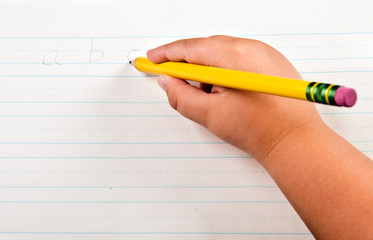 school concept with close up of child's hand writing alphabet
