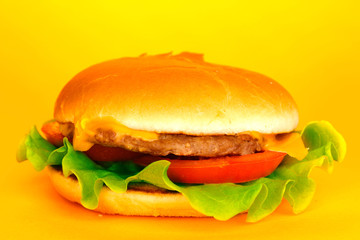 Tasty cheeseburger on yellow background