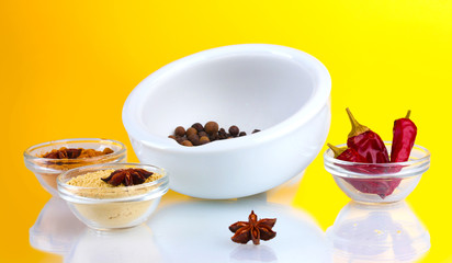 White mortar and pestle with spice on yellow background