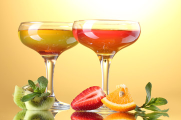 fruit jelly in glasses and fruits on yellow background