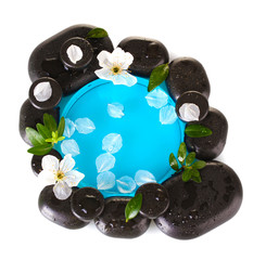 Composition of spa stones, blue water, petals