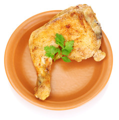 roasted chicken leg with parsley in the plate isolated on white