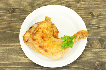 roasted chicken leg with parsley in the plate