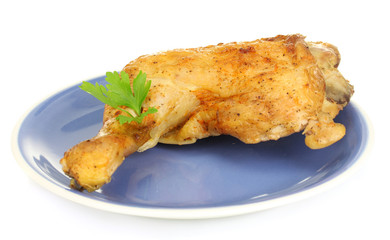 roasted chicken leg with parsley in the plate isolated on white