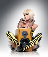 Glamorous sexy young girl with wooden speaker