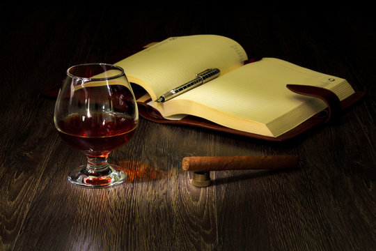 Cognac, cigar and an old book nearby