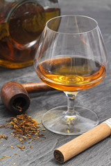 brandy glass and bottle with smoke pipe and cigar