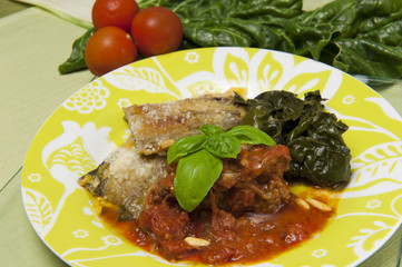 meat rolls in tomato sauce served with spinach