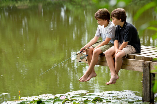 Zwei jungendliche Freunde angeln am idyllischen Teich