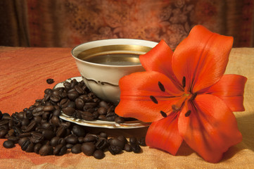 cup with coffee beans and sunflowers on a colored background