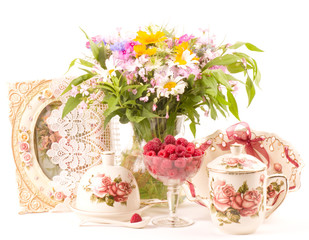 Vintage tea in elegant cups, raspberry and flowers