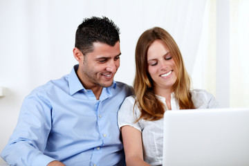 Friendly couple using a laptop