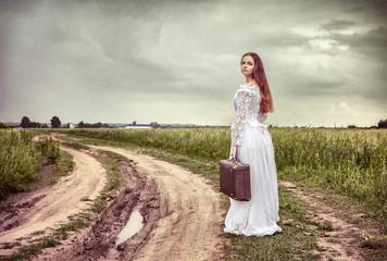 Fototapeta na wymiar The offended bride going with an old suitcase