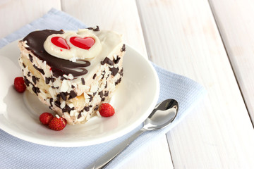 sweet cake with chocolate on plate on wooden table