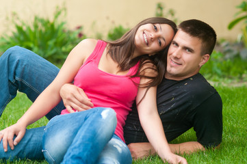 Beautiful young happy couple having fun in the grass