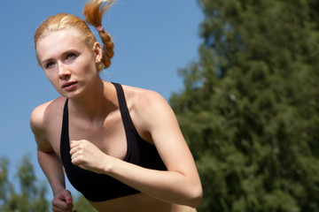 Beautiful young woman runner in nature