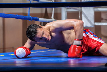 boxer lying knocked out in a boxing ring