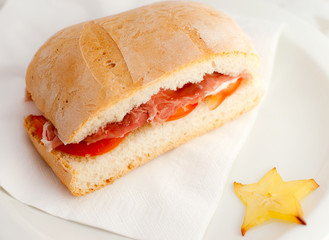 Sandwich with  bread, ham, and tomato.