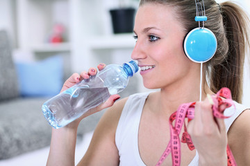 Woman with water bottle and measuring tape
