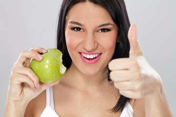 woman with green apple and showing thumb up