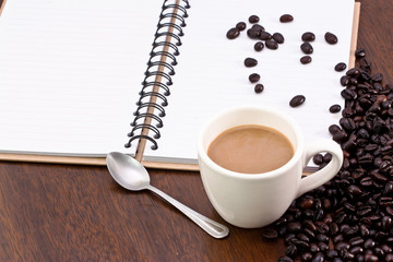 Cup of hot coffee with coffee beans