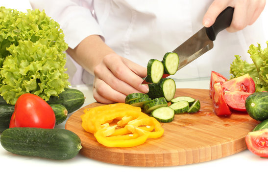 woman hands cutting vegetables on kitchen blackboard