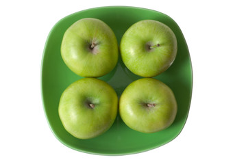 Four green apples on green plate on white background