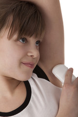 Girl applying deodorant on armpit