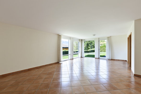 room with terracotta floor, windows overlooking the garden