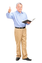 Male teacher holding a book and giving a thumb up