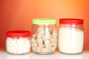 Jars with brown cane sugar lump, white crystal sugar and white