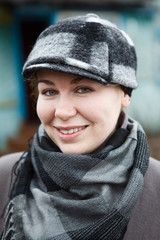 Happy smiling woman close up portrait in cap and scarf