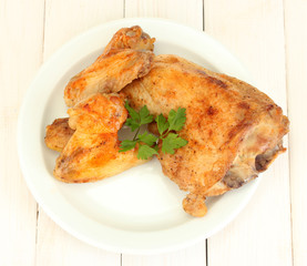 roasted chicken wings and leg with parsley in the plate