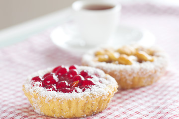 beautiful cake with berries and tea on plaid fabric