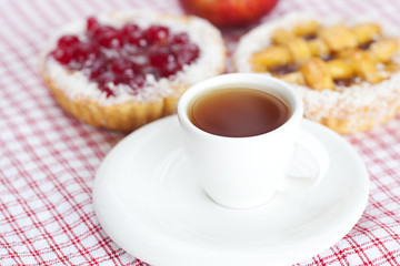 apple,beautiful cake with berries and tea on plaid fabric