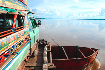 The truck on a ferry to cross the Mekong river