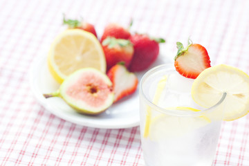 cocktail with ice,lemon, fig and strawberries on a plate