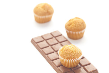 bar of dark chocolate and muffin isolated on white