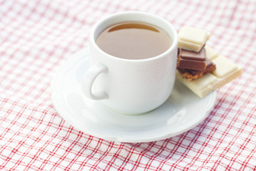 bar of chocolate and tea on plaid fabric