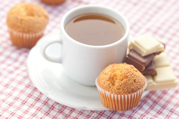 bar of chocolate,tea and muffin on plaid fabric