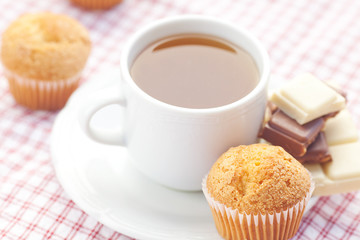 bar of chocolate,tea and muffin on plaid fabric