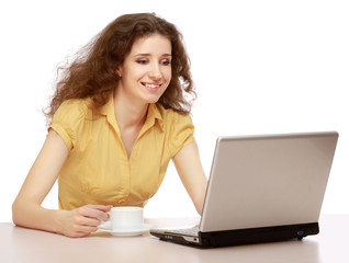 Beautiful smiling girl sitting at table with laptop