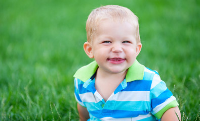funny little boy over green grass