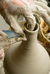 hands of a potter, creating an earthen jar on the circle