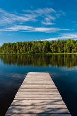 Obraz na płótnie Canvas Wooden pier on lake symmetrical scene