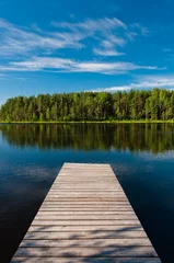 Foto auf Acrylglas Wooden pier on lake symmetrical scene © dmitryelagin