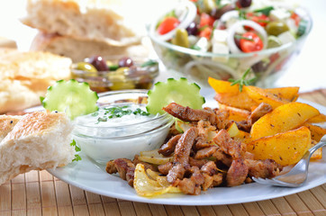 Gyros mit Bratkartoffeln, Tsatsiki, Pitabrot und Bauernsalat