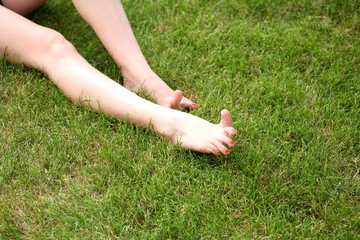 Womans bare feet on green grass